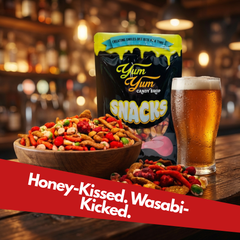 Hot Honey Snack Mix served in a bowl with a glass of beer in a bar setting featuring sweet and spicy snack blend