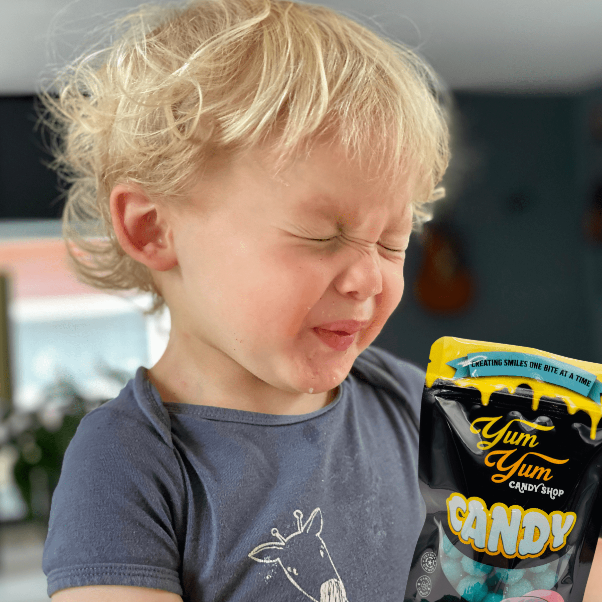 Young child making a funny sour face after tasting the extreme sour candy