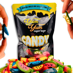 Yum Yum Candy Shop bag with colorful candy pieces spilling out, held by hands.
