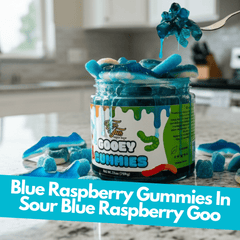 Jar of sour blue raspberry gooey gummies with dripping blue raspberry goo on a kitchen counter