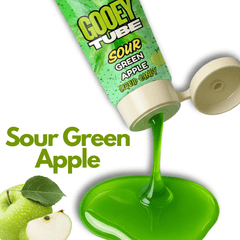 Sour green apple liquid candy tube with green liquid spilling out, next to a green apple.