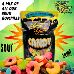 A pile of sour gummy candies in front of Yum Yum Candy Shop bag with comic-style burst and "Sour!" text