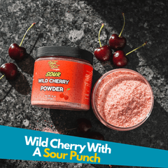Jar of sour wild cherry powder with a bowl of cherry powder and fresh cherries on a dark stone surface
