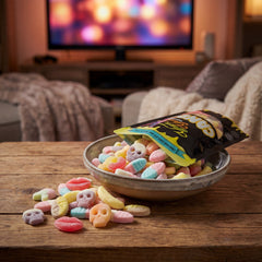 A black Yum Yum Candy bag of Swedish gummies spilling into a bowl