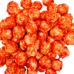 Pile of Chamoy Piña Colada Sours showing vibrant red chamoy coating over pineapple-coconut sour candies.