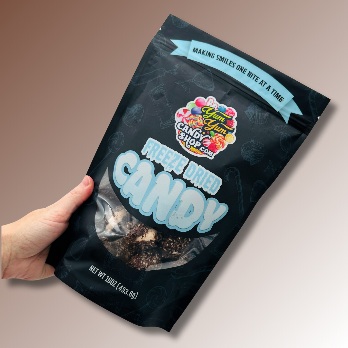 Hand holding a 1 lb bag of Freeze Dried Chocolate Coconut Mallow Bites.