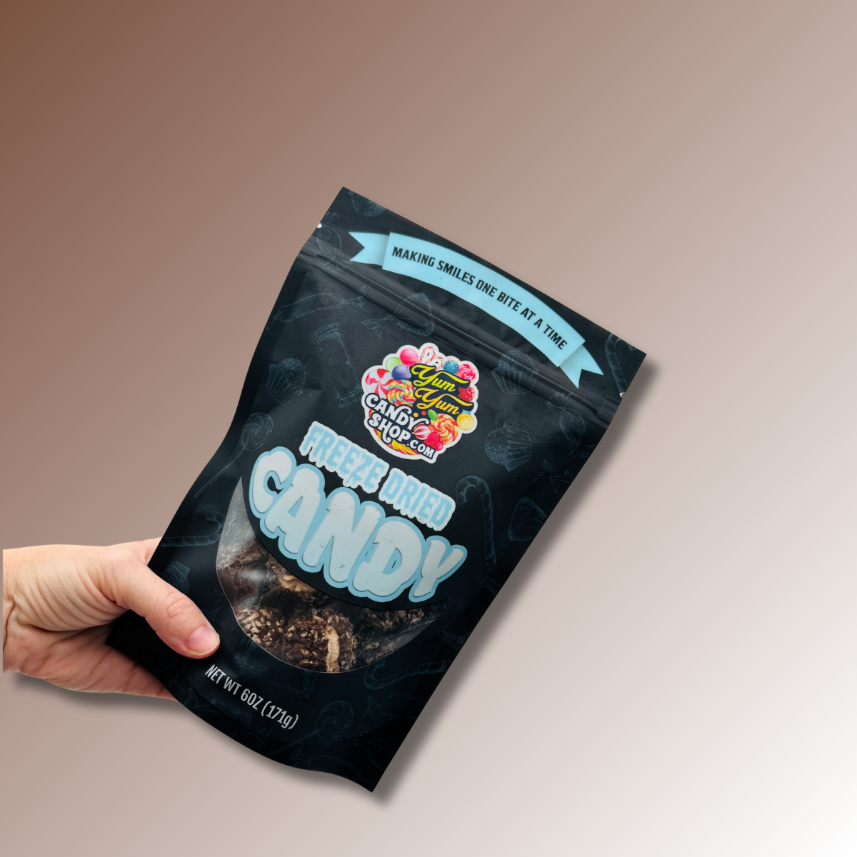 Hand holding a 6 oz bag of Freeze Dried Chocolate Coconut Mallow Bites.