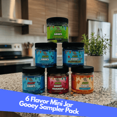 Collection of 6 mini jars with colorful labels on a kitchen counter.