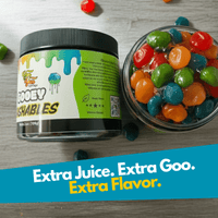 Jar of colorful gooey goshables with a label on a wooden surface.