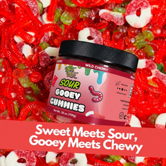Jar of Sour Gooey Gummies surrounded by red and green gummy candy on a red background.