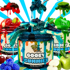 Gooey gummies with colorful packaging and fruit toppings on a blue and white striped background.