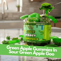 Jar of green apple gooey gummies on a kitchen counter.
