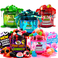 Lineup of Yum Yum sticky gooey gummies jars in Sour Green Apple, Blue Raspberry, Wild Cherry, Spooky, and Cotton Candy flavors with gummies spilling out